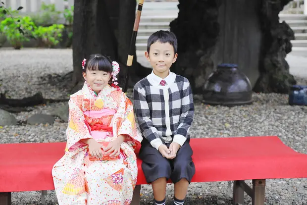 男の子と着物姿の女の子がベンチに座っている