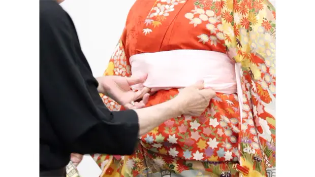 振袖の上に伊達締めを結ぶ