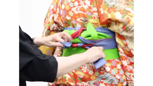 袴のひもを帯にからめて結ぶ