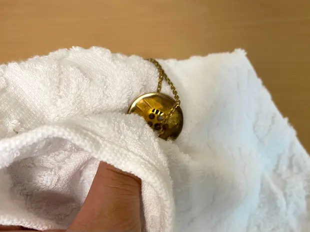 ネックレスをタオルで拭く