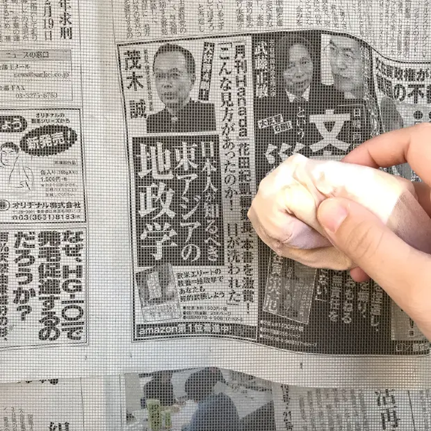 丸めたストッキングで網戸を拭いている