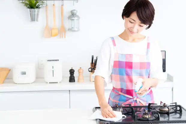 ガスコンロを掃除する女性