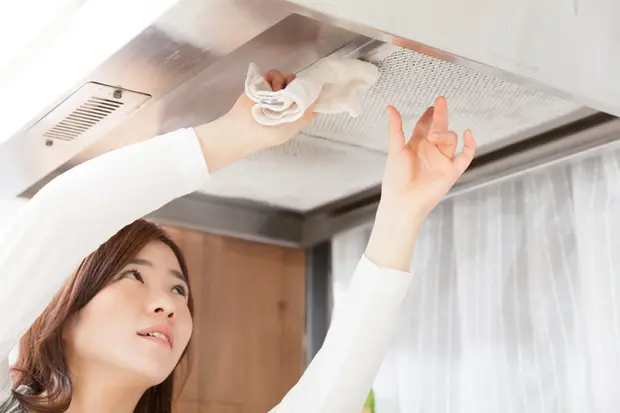 レンジフードを拭く女性