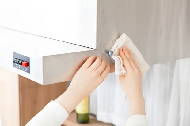 換気扇の汚れを拭いている