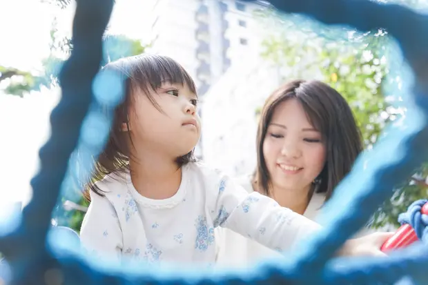 ジャングルジムで遊ぶ子供と母親