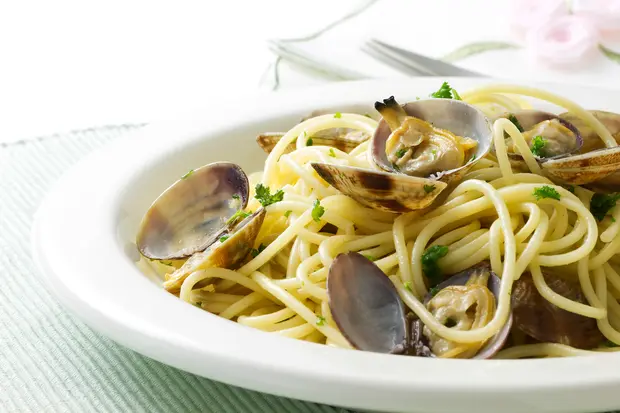 テーブルに置かれた丸皿のパスタ1