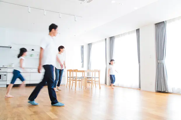 リビングを歩く家族