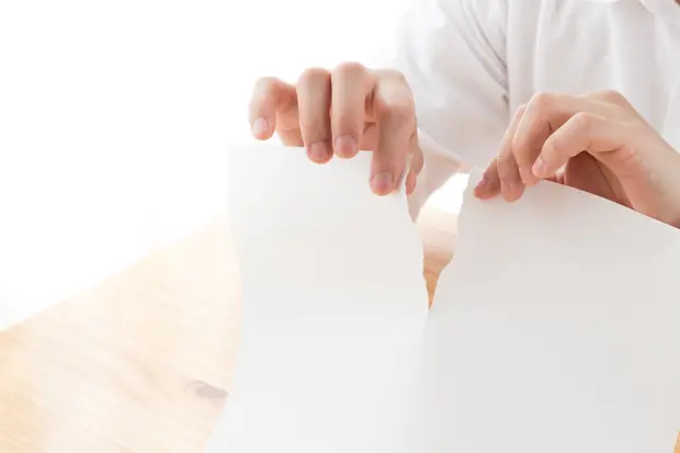 紙を破く手