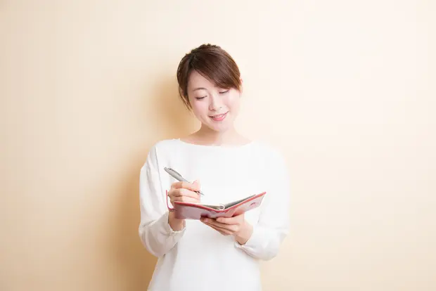 ノートに書き込む女性